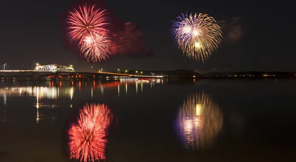 Fogos de artifício sobre a água e ponte — Fotografia de Stock