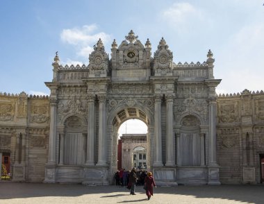 İstanbul, Türkiye - 2 Nisan 2017: Dolmabahçe Sarayı'nın kapısında yürüyen turistler.