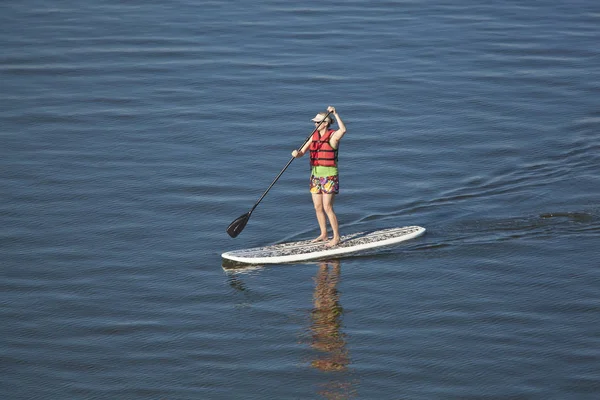 Mulher stand up paddleboarding — Fotografia de Stock