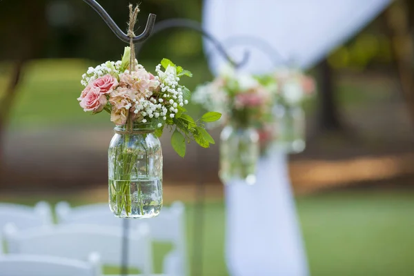 結婚式で石工瓶にぶら下がるバラの花束 — ストック写真