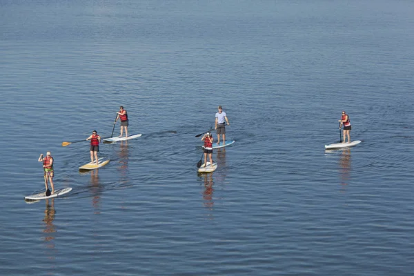Grupo de pessoas se levantar paddleboarding — Fotografia de Stock