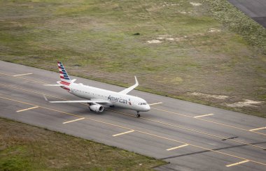 NEW YORK, UNITED STATES OF AMERICA-JUNE 17, 2019: An American Airlines commuter jet moves across the tarmac of JFK International Airport in New York in this aerial view. clipart