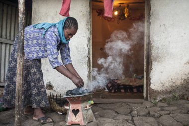 Oromia, Etiyopya - 1 Kasım 2014: Basit evde kömür ateşi nde yemek pişiren yerel kadın.