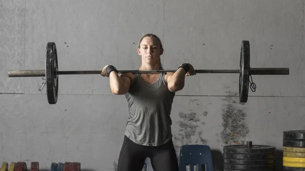 Молодая сильная женщина пауэрлифтер тренировки в тренажерном зале, крупным планом — стоковое фото