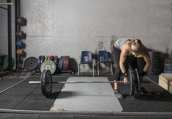 バーベルに重量をロードする若い女性のパワーリフター — ストック写真