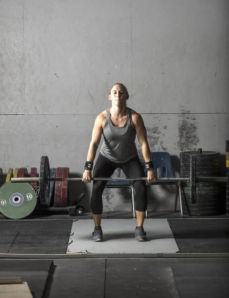 Joven mujer poderosa levantando pesas pesadas en el gimnasio . —  Fotos de Stock