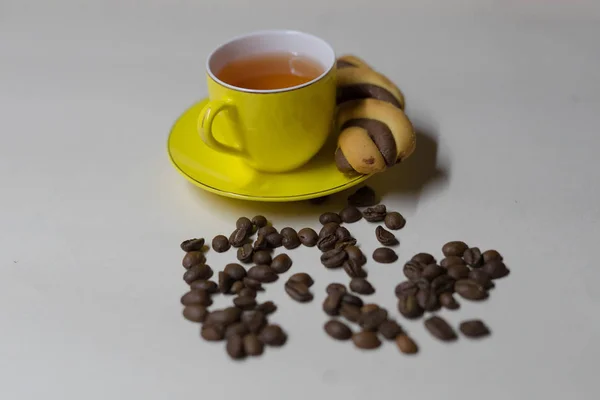 Mug kuning teh, biji-bijian kopi dan kue — Stok Foto
