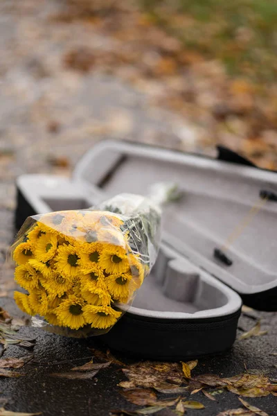 Een cover van een viool en gele bloemen erin — Stockfoto