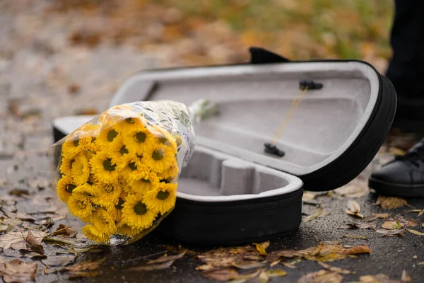 Een cover van een viool en gele bloemen erin — Stockfoto