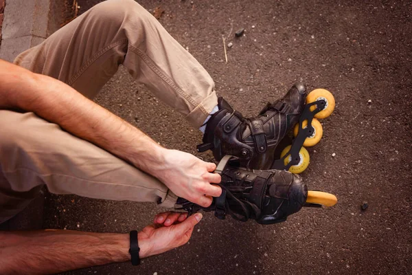 Man Sitting Ground Puts Black Rollers Tying Shoelaces — Stock Photo, Image