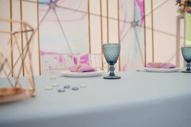 Düğün için mavi bardaklar ve tabaklar masada.