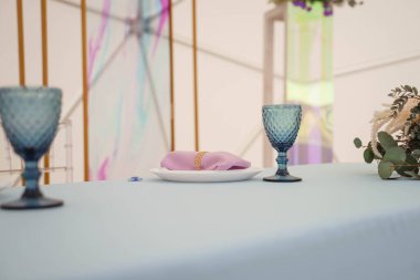 Düğün için mavi bardaklar ve tabaklar masada.