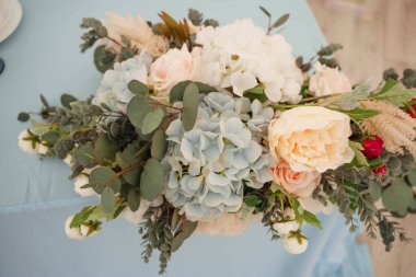 Masada bir buket suni çiçek var.