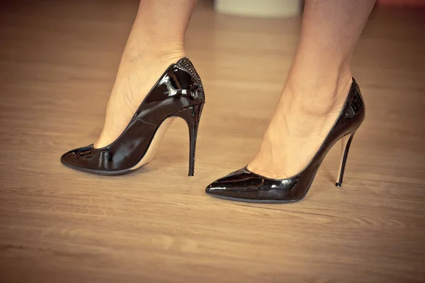 Kvinnliga ben i patent svarta skor — Stockfoto