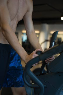 Bir adam koşu bandında çalışır ve hızı ayarlar.