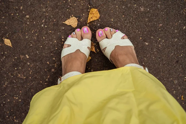 Mänskliga fötter i skor på hösten marken — Stockfoto