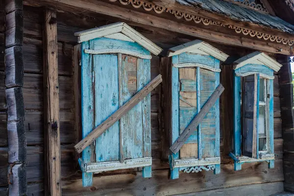 Vieja casa abandonada con bonitas persianas azules — Foto de Stock