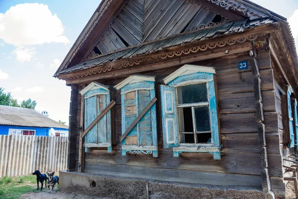 Vieja casa abandonada con bonitas persianas azules — Foto de Stock