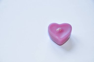 beyaz arka plan üzerinde kalp şeklinde mum