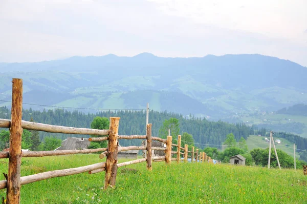 山を背景に野原の木製フェンス — ストック写真