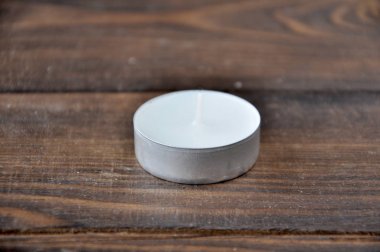 küçük bir mum ahşap bir masa üzerinde duruyor