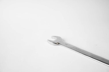 bir İngiliz anahtarı beyaz bir arka plan üzerinde bir masa üzerinde yatıyor