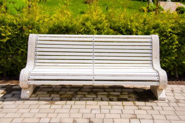 Ahşap elemanları ile büyük beton banklar. ParkTaki ara sokağa yakın. Bahçede yaz. Yaz günü.
