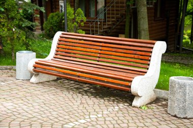 Ahşap elemanları ile büyük beton banklar. ParkTaki ara sokağa yakın. Bahçede yaz. Yaz günü.