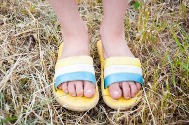 şort ve flip-flop biçilmiş çim üzerinde duran küçük kız