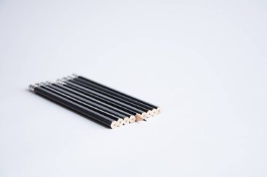 Beyaz masada bir sürü siyah kalem var. Bir kalem keskinleştirilmiş. Office