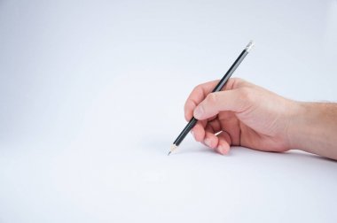siyah kalem sağ elinde tutar. beyaz bir arka plan üzerine çizer