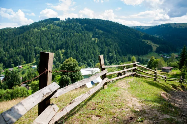 Dağlarda eski ahşap çit. Orman ve uzun ağaçlar. Dağlar ve tepeler. Yaz