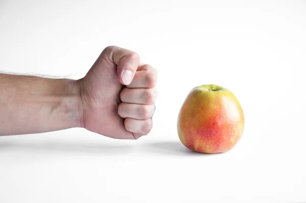 Una Mela Poggia Tavolo Bianco Uno Sfondo Bianco Mano Stretta — Foto Stock