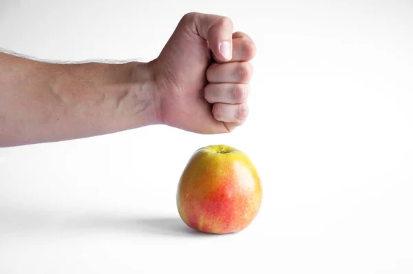 一个苹果站在白色背景的白色桌子上 手紧握在苹果附近的拳头 — 图库照片