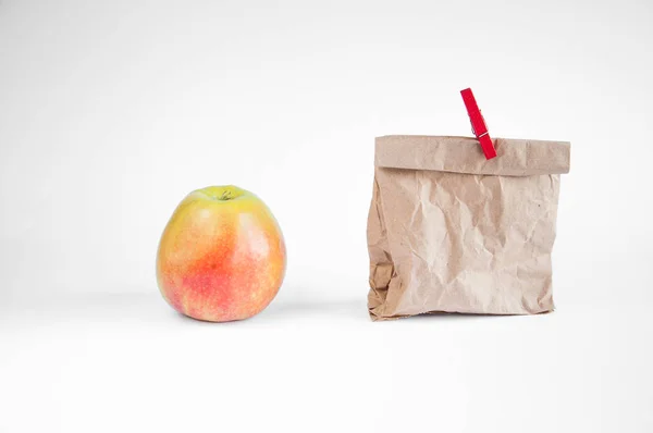 Papírzacskót Fehér Alapon Áll Asztalon Közel Fekszik Egy Almát Jelen — Stock Fotó