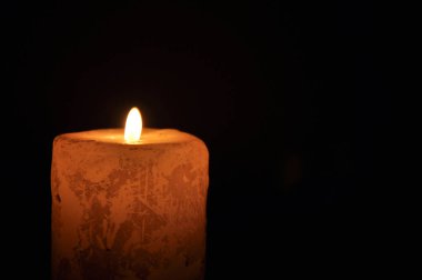 Karanlıkta büyük mum yanıyordu. Siyah bir arkaplanda.