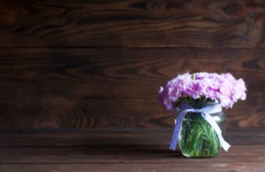 Vazoda bir buket güzel pembe çiçek. Ahşap arkaplan.