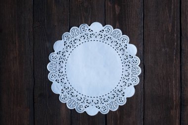 Ahşap arka planda beyaz dantelli altlık.
