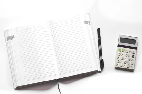 Open Het Notitieboek Rekenmachine Pen Een Witte Tafel — Stockfoto