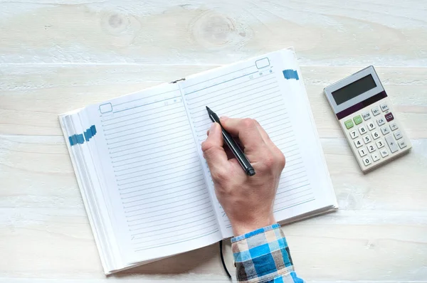 Main Homme Affaires Écrit Dans Cahier Calculatrice Sur Une Table — Photo