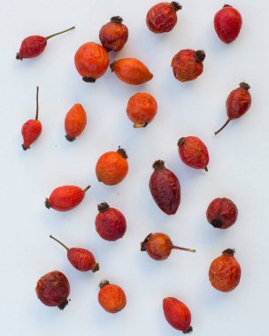 Beyaz arka planda kırmızı gül kalçası üzümü