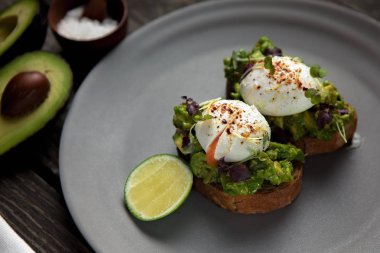 İki haşlanmış yumurta ve limonlu avokado tostu.