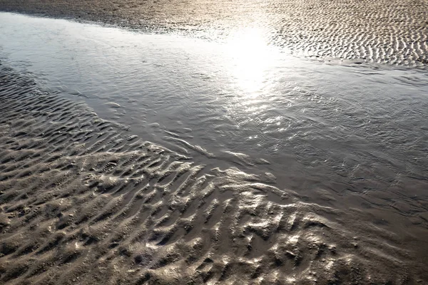 riflesso del sole sulla sabbia e sull'acqua del mare