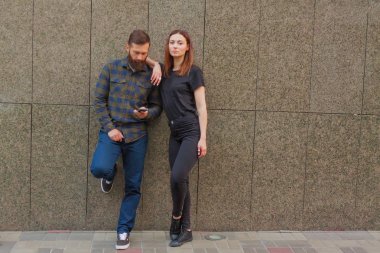 Şık çift duvar arka plan üzerinde akıllı telefonlar ayakta kullanarak