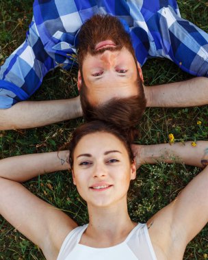 Çift çim üzerinde yalan. Sevimli küçük kız ve açık acımasız sakallı adam. Yukarıdan görüntülemek