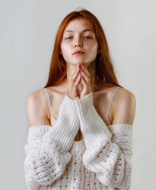 Fotoğraf umutlu Redhead kadın eller birlikte kamera, çıplak omuz gri arka plan kopya alanı üzerinde poz süre bakarak örme kazak giymiş bir jest, dua etmenin tutar.