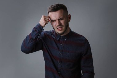 Stresli genç adam fotoğrafı korkunç baş ağrısı, sinirli ve depresif, clenches diş acı içinde olmak hissediyor, ağrısı muzdarip, gözlerini kapatır, sorun vardır. Koyu gri arka plan kopya alanı