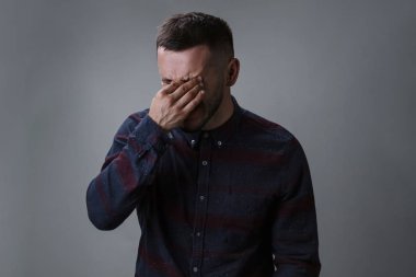 Yorgun ve gri arka plan karşı dinlenmek isteyen kıl gözler, sürtünme sırasında yorgun adamla portresi. Yorgunluk kavramı