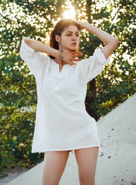 Çıplak ayaklı uzun beyaz gömlekli büyüleyici bir esmer kum üzerinde duran sıcak yaz günü teşkil etmektedir. Güneş ışınlarının altın saat her yerde ağaç yapraklarda görülür