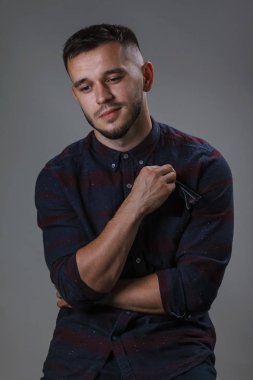 Kareli gömlek ve güçlü siyah plastik glasess düşük görme için elinde bir koyu gri arka plan üzerinde duruyor iken giyen çekici erkek